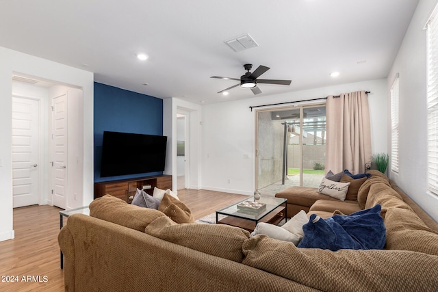 living room with light hardwood / wood-style flooring and ceiling fan