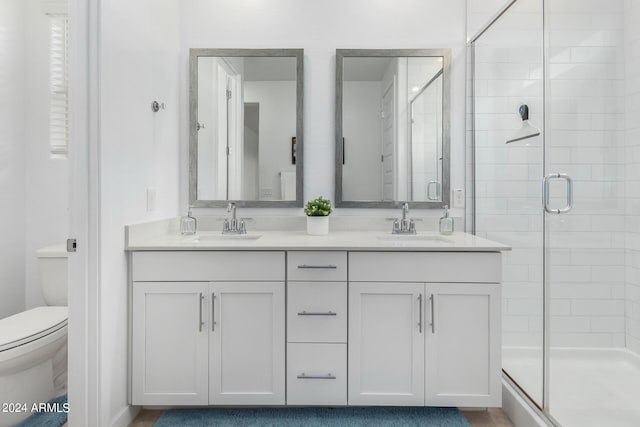 bathroom with vanity, toilet, and an enclosed shower