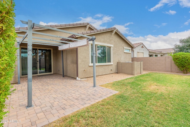 rear view of property featuring a patio and a lawn