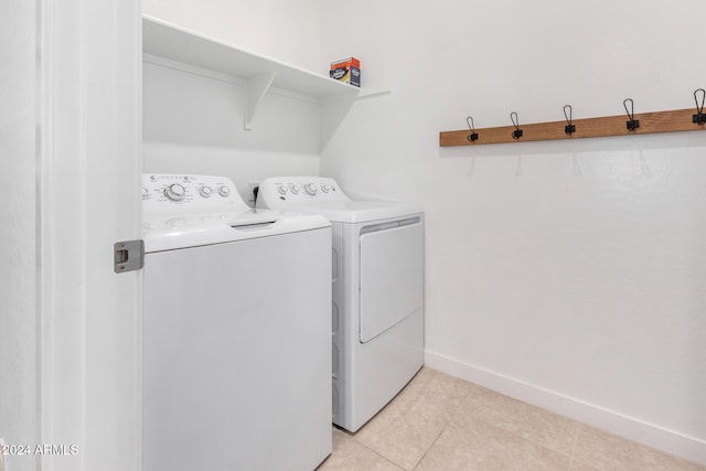 laundry area with washer and clothes dryer and light tile patterned floors