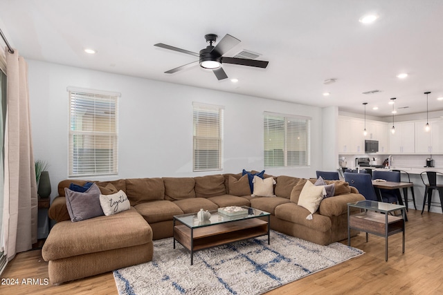 living room featuring light hardwood / wood-style flooring and ceiling fan