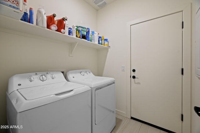 laundry room featuring separate washer and dryer and light hardwood / wood-style floors