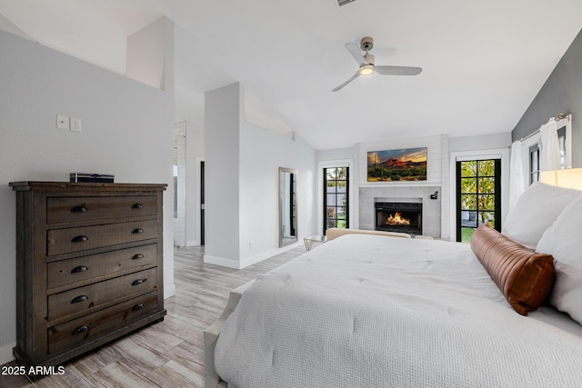 bedroom featuring a fireplace, light hardwood / wood-style flooring, high vaulted ceiling, and ceiling fan