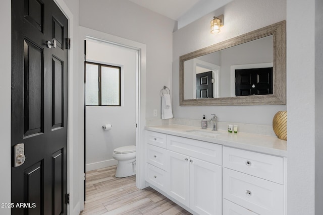 bathroom with wood-type flooring, vanity, and toilet