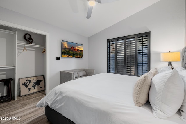 bedroom with hardwood / wood-style flooring, lofted ceiling, ceiling fan, and a closet