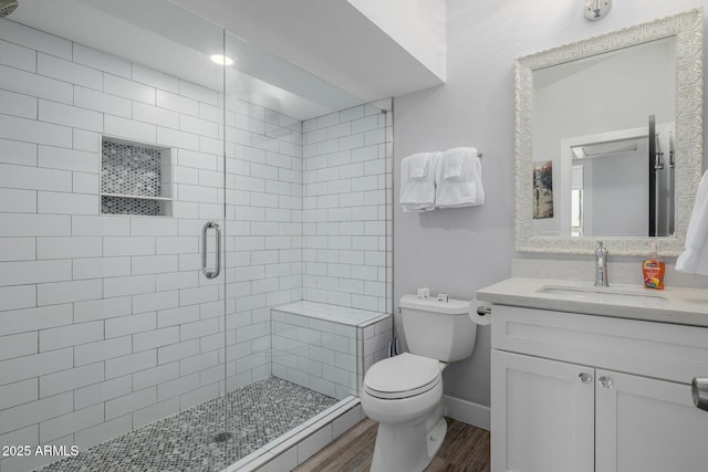 bathroom featuring vanity, toilet, a shower with shower door, and hardwood / wood-style floors