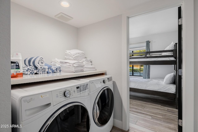 washroom featuring independent washer and dryer and light hardwood / wood-style flooring