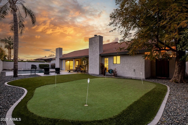 back house at dusk with a patio area