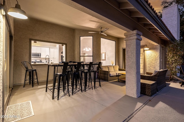 view of patio / terrace with an outdoor living space, a wet bar, and ceiling fan