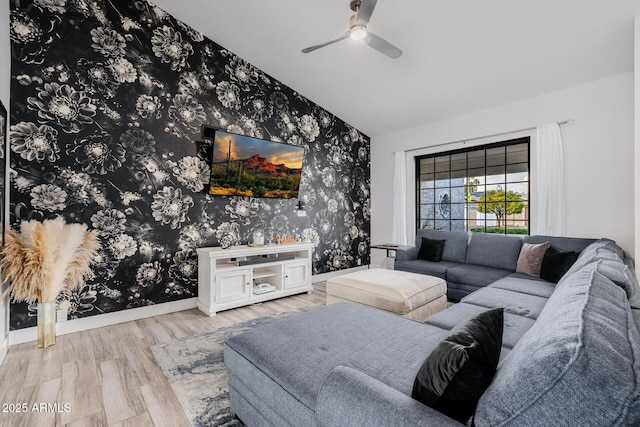 living room featuring vaulted ceiling, ceiling fan, and light wood-type flooring