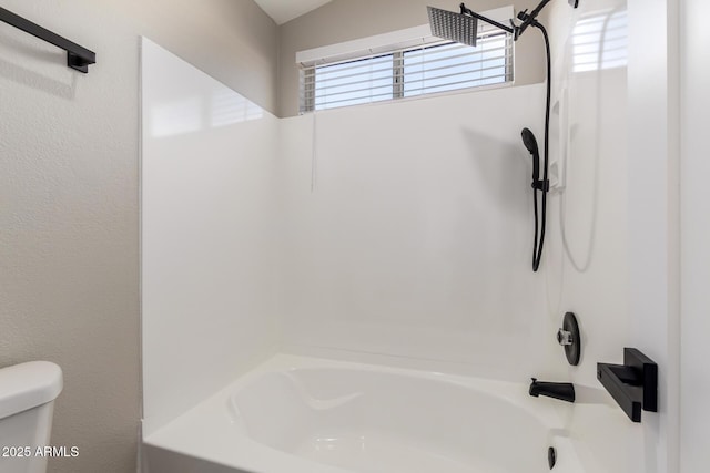 bathroom featuring shower / washtub combination and toilet