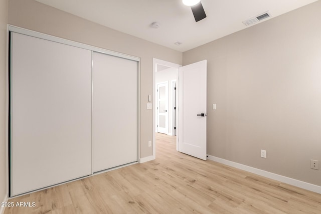 unfurnished bedroom with light hardwood / wood-style floors, a closet, and ceiling fan