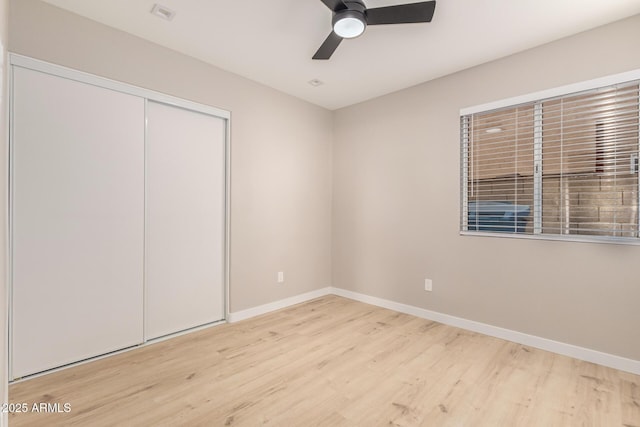 unfurnished bedroom featuring light hardwood / wood-style flooring, a closet, and ceiling fan