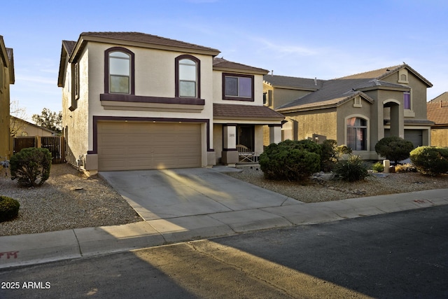 view of front of property featuring stucco siding, concrete driveway, a garage, and fence