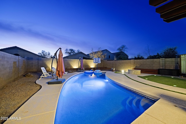 pool at dusk featuring a patio area, a fenced in pool, and a fenced backyard