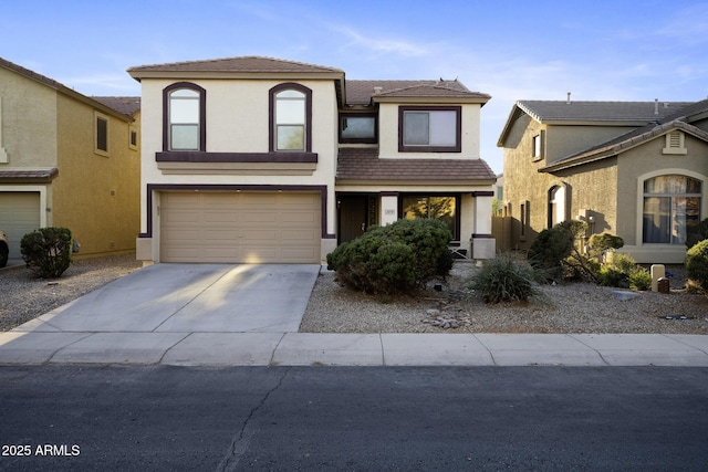 view of front of property with concrete driveway, an attached garage, and stucco siding