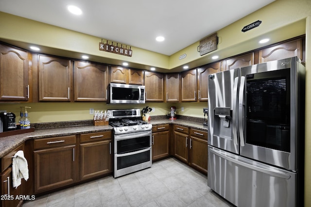 kitchen featuring dark countertops, light tile patterned floors, recessed lighting, and stainless steel appliances