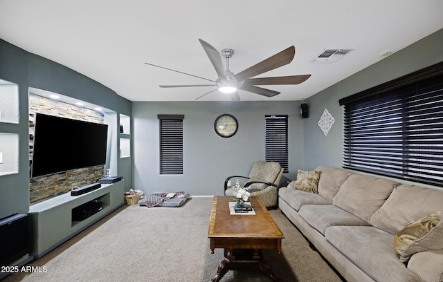 carpeted living area featuring visible vents and a ceiling fan