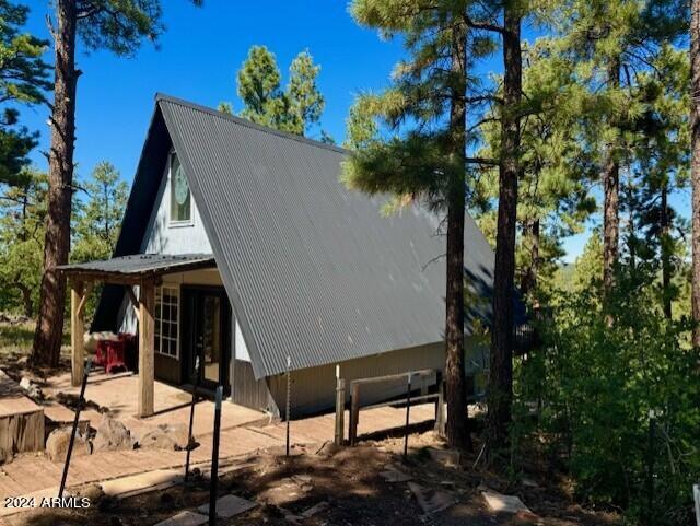 1725 Turkey Mountain Rd, Happy Jack, AZ 86024 - view of side of home featuring metal roof and a patio