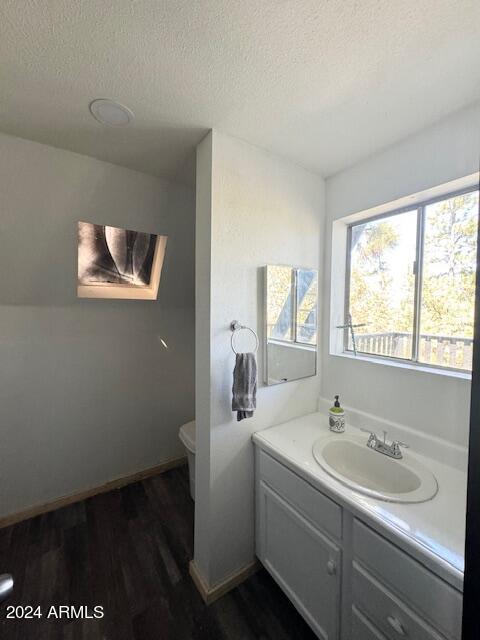1725 Turkey Mountain Rd, Happy Jack, AZ 86024 - half bathroom featuring a textured ceiling, wood finished floors, toilet, and vanity