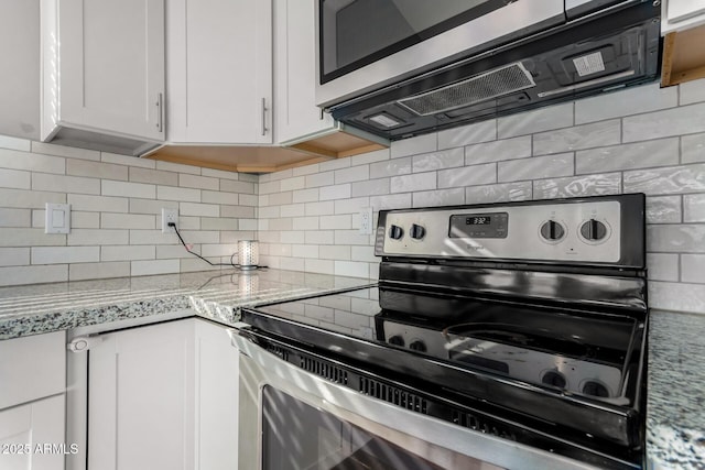 kitchen featuring stainless steel appliances, tasteful backsplash, light stone countertops, and white cabinets