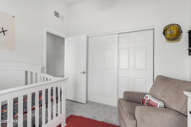 bedroom featuring light colored carpet and a closet