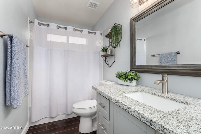 full bathroom featuring vanity, shower / bath combo, and toilet