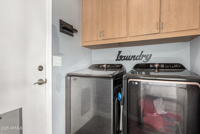 laundry room with washer and dryer and cabinets