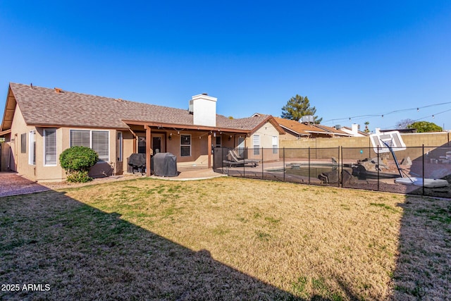 back of house with a yard and a patio area