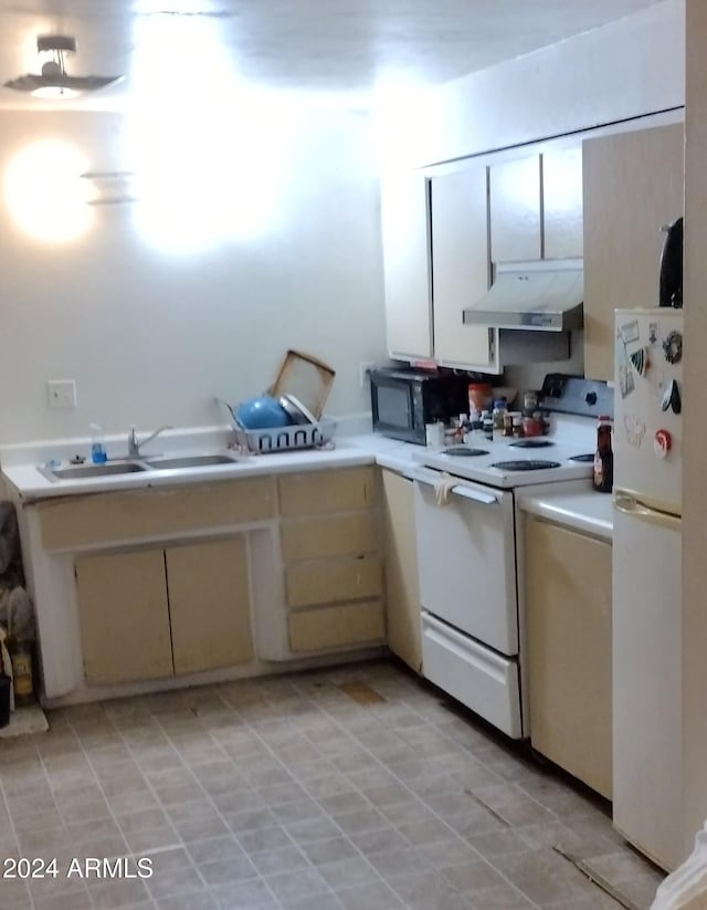 kitchen featuring cream cabinetry, white appliances, and sink