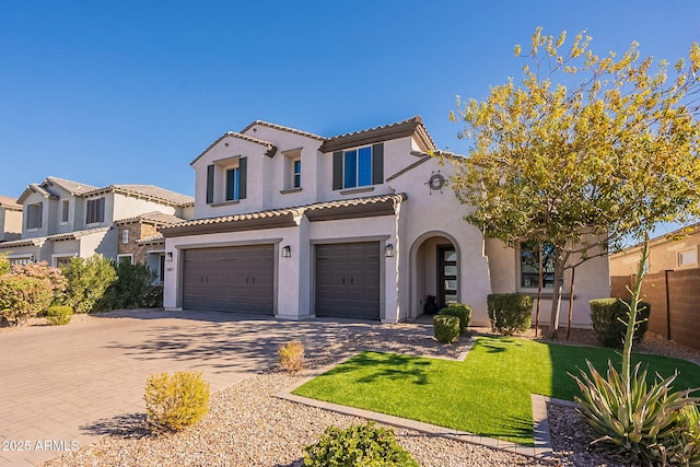 mediterranean / spanish-style home featuring a garage and a front yard