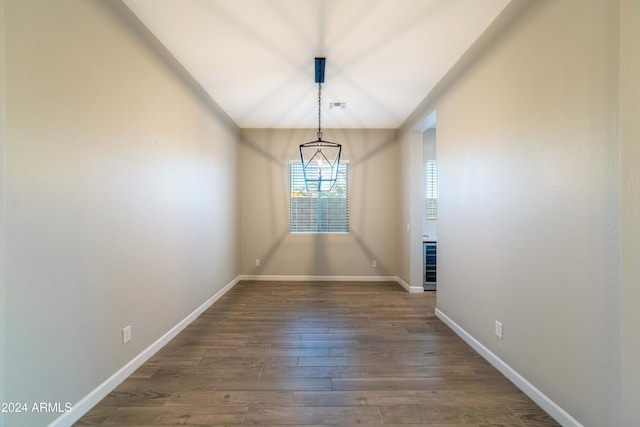 unfurnished dining area featuring wine cooler, dark hardwood / wood-style flooring, and vaulted ceiling