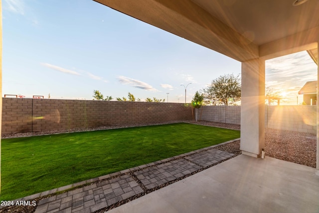 yard at dusk featuring a patio