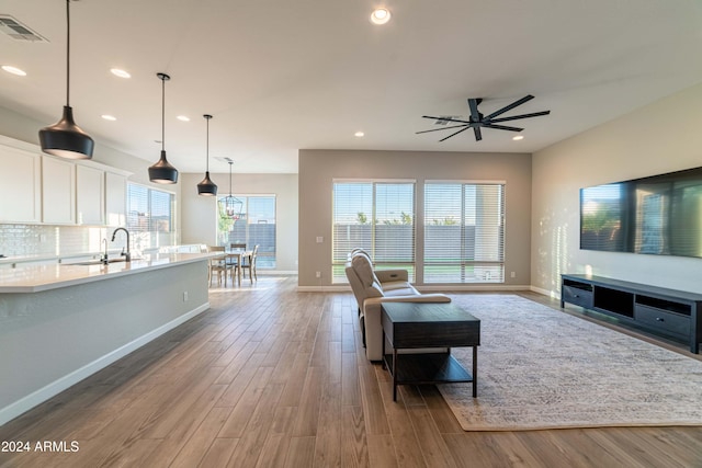 living room with hardwood / wood-style flooring, ceiling fan, and sink