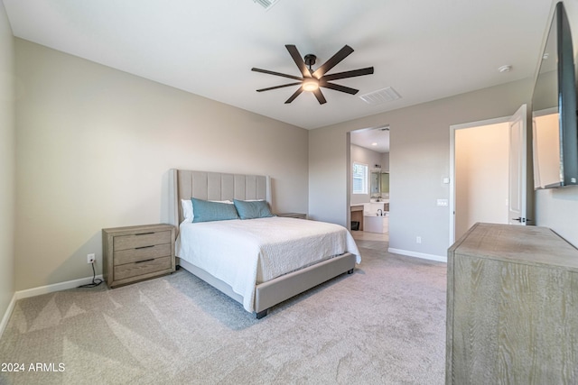 bedroom featuring ceiling fan, ensuite bathroom, and light carpet