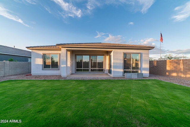 back of house featuring a patio area and a lawn