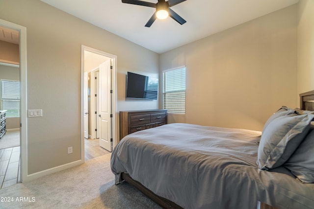 carpeted bedroom featuring multiple windows and ceiling fan