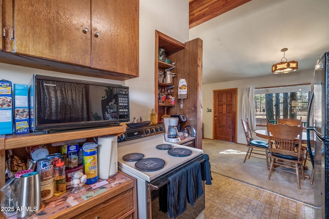 kitchen with stainless steel refrigerator, light colored carpet, white range with electric stovetop, and decorative light fixtures