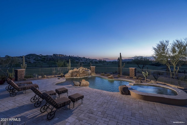 9161 E Superstition Mountain Dr, Gold Canyon, AZ 85118 - pool at dusk with an in ground hot tub and a patio area