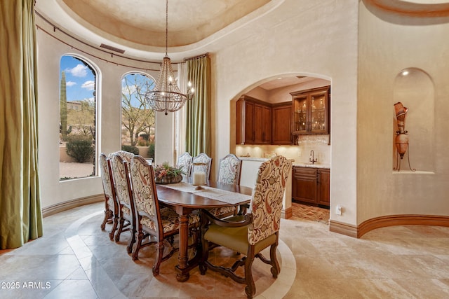 9161 E Superstition Mountain Dr, Gold Canyon, AZ 85118 - dining area featuring a raised ceiling, sink, a notable chandelier, and a towering ceiling