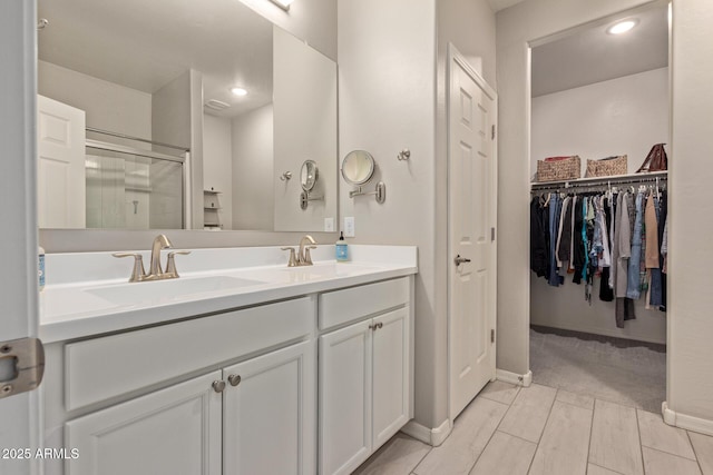 bathroom with a shower with door and vanity