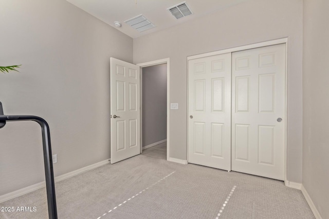 unfurnished bedroom with a closet and light colored carpet