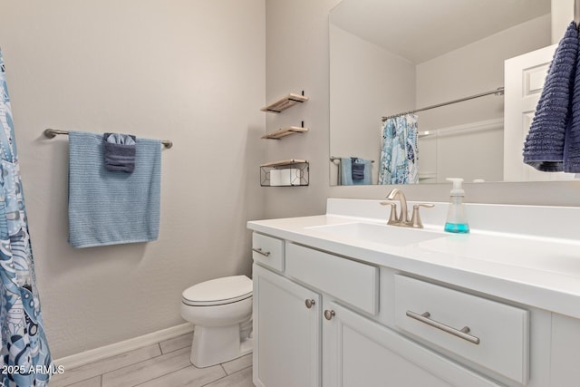 bathroom featuring toilet, walk in shower, and vanity