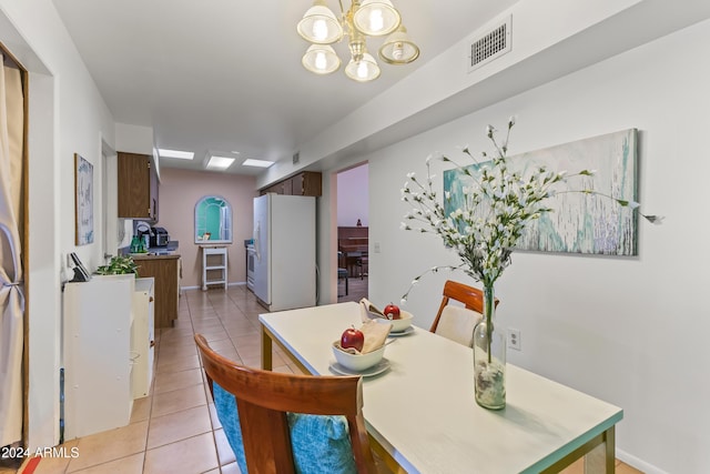 tiled dining space with a notable chandelier