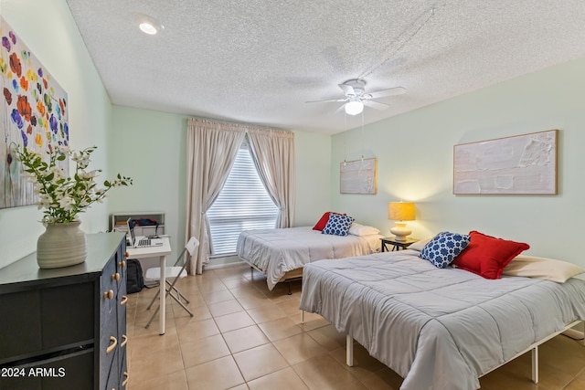 tiled bedroom with a textured ceiling and ceiling fan