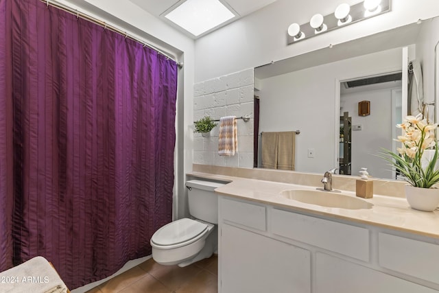 bathroom with toilet, vanity, and tile patterned floors