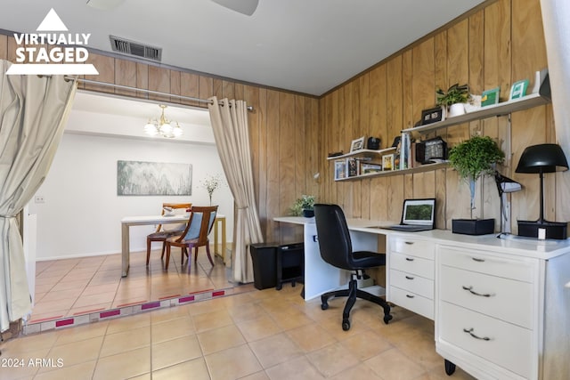 office space with a chandelier, light tile patterned floors, and wooden walls