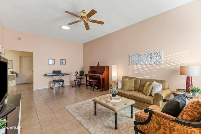 living room featuring ceiling fan, light tile patterned flooring, and a textured ceiling