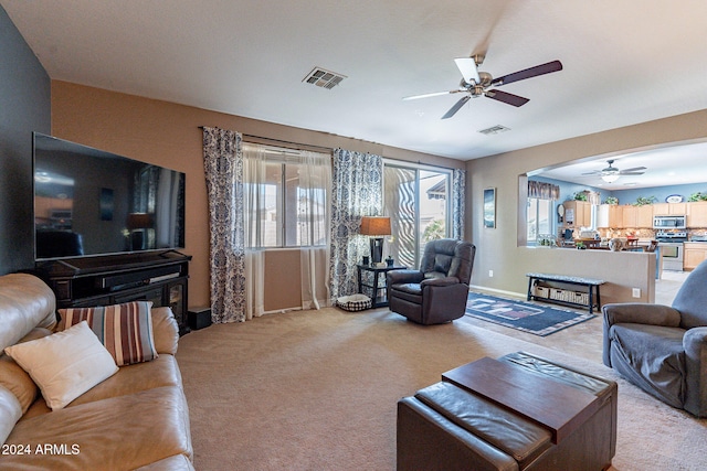 living room with ceiling fan and light colored carpet