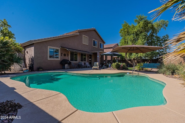 view of pool with a patio area and a grill